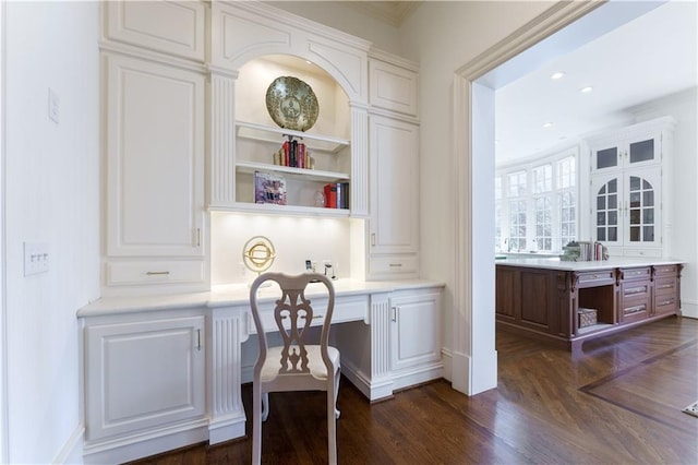 office space featuring dark hardwood / wood-style floors and built in desk