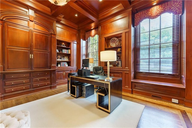 home office featuring coffered ceiling, wood walls, ornamental molding, built in features, and a wealth of natural light