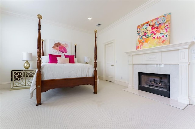 bedroom featuring crown molding, a tile fireplace, and light carpet