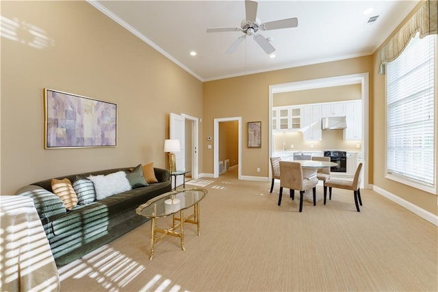 living room with crown molding, light colored carpet, and ceiling fan