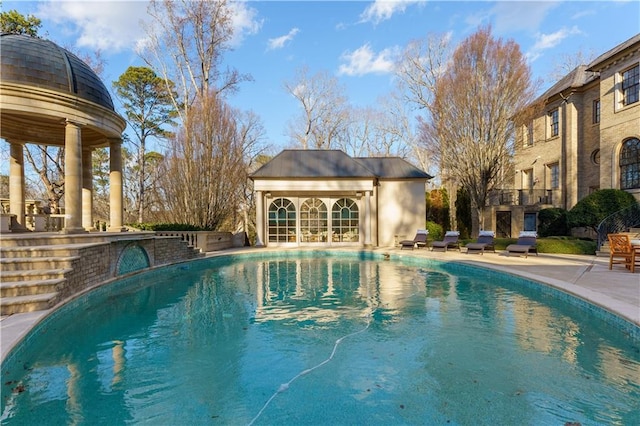 view of swimming pool featuring a patio and an outdoor structure