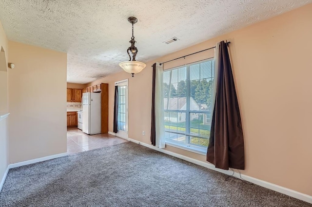 unfurnished dining area with baseboards, light carpet, a textured ceiling, and visible vents