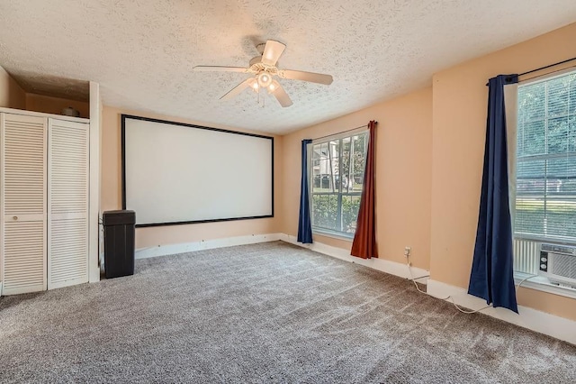 cinema room with baseboards, ceiling fan, carpet flooring, and a textured ceiling