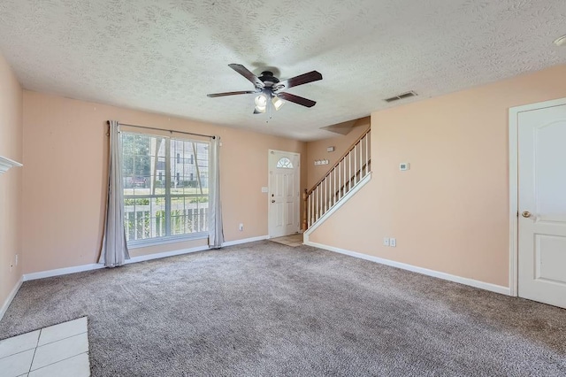 unfurnished living room with visible vents, carpet flooring, baseboards, a textured ceiling, and a ceiling fan