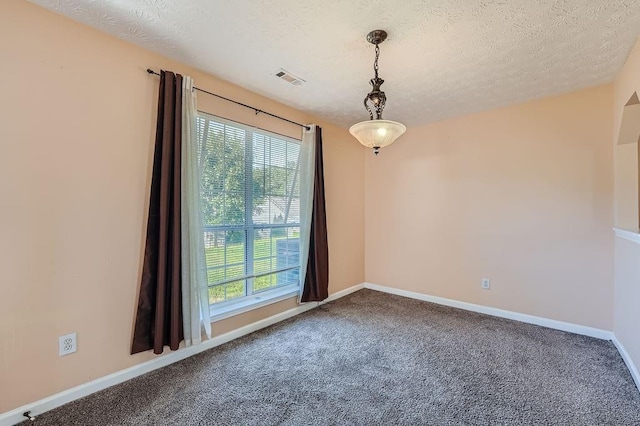 carpeted empty room with a textured ceiling, baseboards, and visible vents
