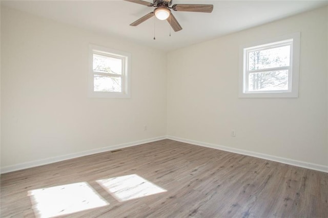 spare room with baseboards and a healthy amount of sunlight