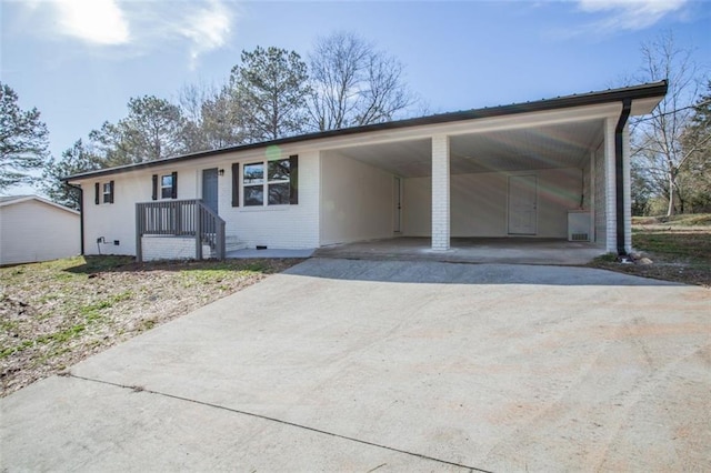 ranch-style home featuring brick siding, an attached carport, and driveway