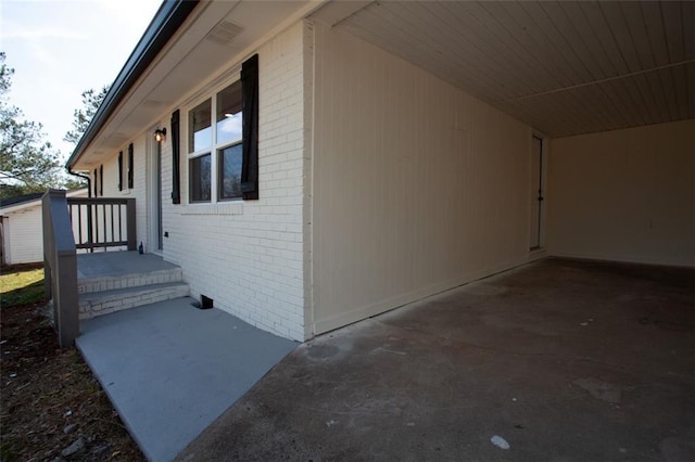 view of home's exterior with brick siding, crawl space, and an attached carport