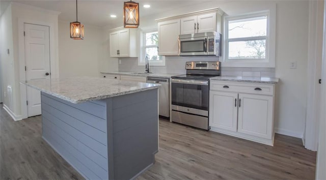 kitchen featuring a sink, white cabinets, backsplash, and stainless steel appliances