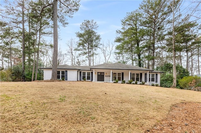 ranch-style house with a front yard and covered porch