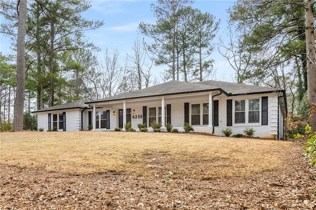 single story home featuring a porch and a front lawn