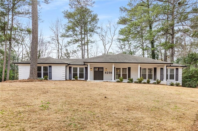 ranch-style home with a front lawn and covered porch