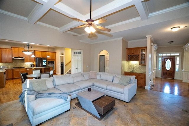 living room featuring ceiling fan, coffered ceiling, crown molding, and beamed ceiling