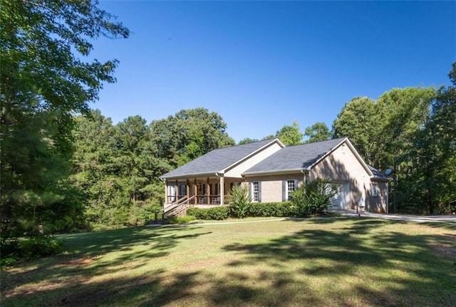 view of front of house with a garage, a front lawn, and covered porch