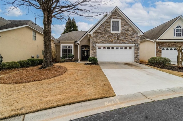 view of front facade with stone siding, driveway, and stucco siding