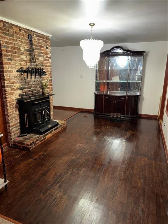 unfurnished dining area featuring a wood stove, baseboards, and wood-type flooring