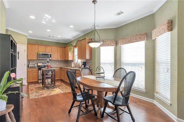 dining space with wood finished floors, baseboards, visible vents, recessed lighting, and ornamental molding