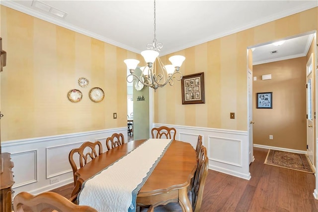 dining space with ornamental molding, wood finished floors, wainscoting, wallpapered walls, and a chandelier