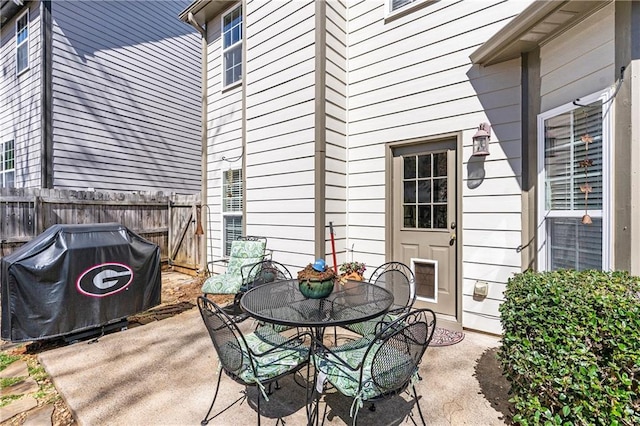 view of patio featuring fence and a grill