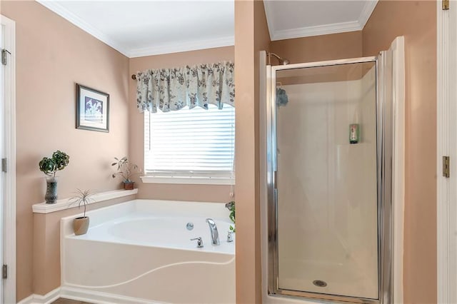 bathroom featuring a stall shower, a garden tub, and ornamental molding