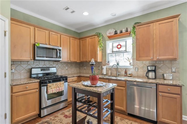 kitchen with a sink, stainless steel appliances, tasteful backsplash, and visible vents