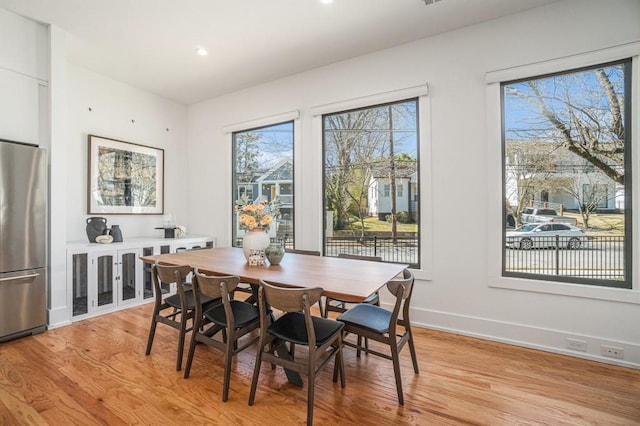 dining area with light wood-type flooring, baseboards, and recessed lighting