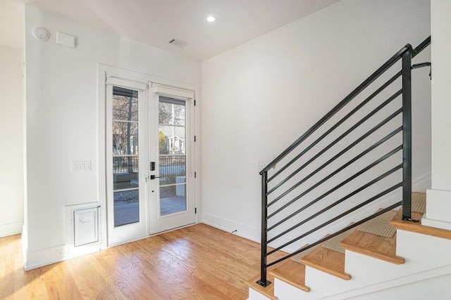 doorway to outside with visible vents, baseboards, wood finished floors, stairs, and recessed lighting