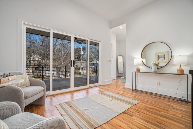 sitting room with a high ceiling, wood finished floors, and baseboards