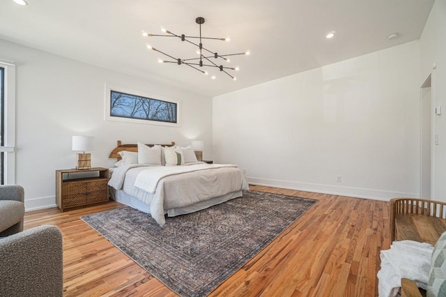 bedroom with a chandelier, recessed lighting, light wood-style flooring, and baseboards