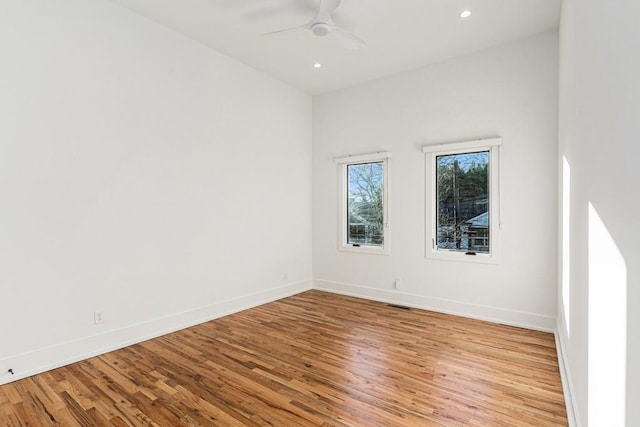 empty room with ceiling fan, recessed lighting, light wood-style flooring, and baseboards