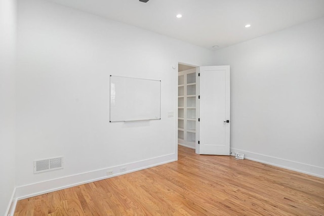 spare room with light wood-type flooring, baseboards, visible vents, and recessed lighting