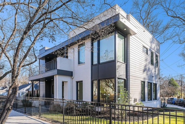 view of side of home with a fenced front yard and brick siding