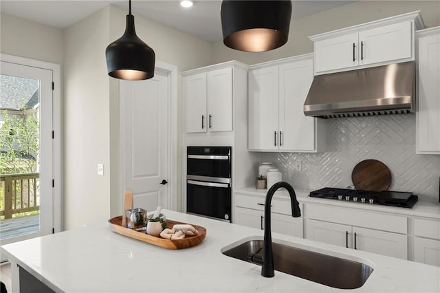 1941 Quarry Park Pl NW, Atlanta, GA 30318 - kitchen featuring under cabinet range hood, stainless steel gas cooktop, a sink, backsplash, and white cabinets