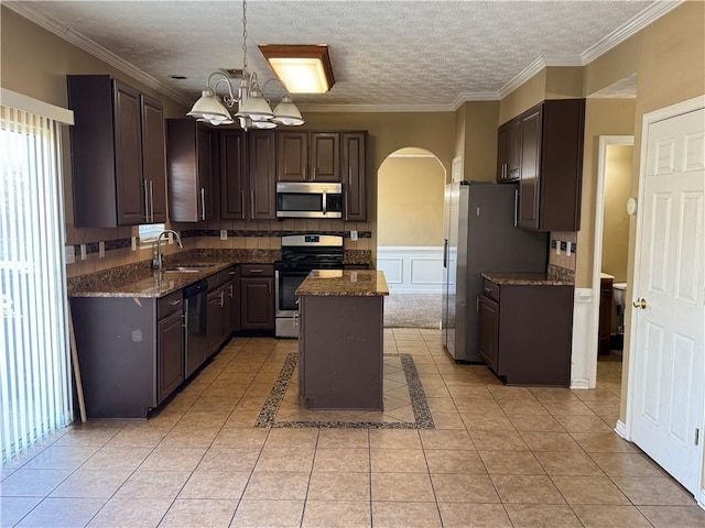 kitchen featuring sink, crown molding, a chandelier, a kitchen island, and appliances with stainless steel finishes