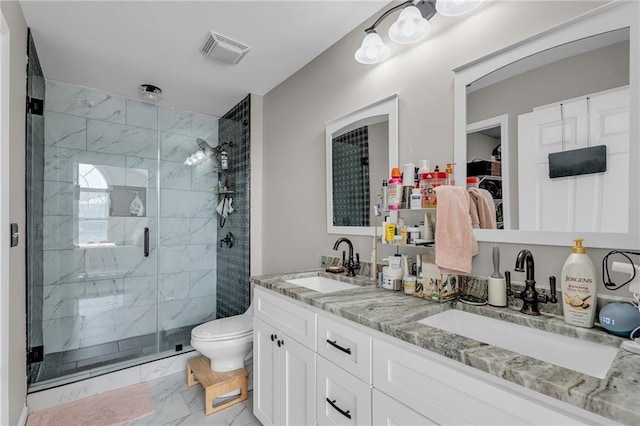 bathroom with vanity, a shower with door, and toilet