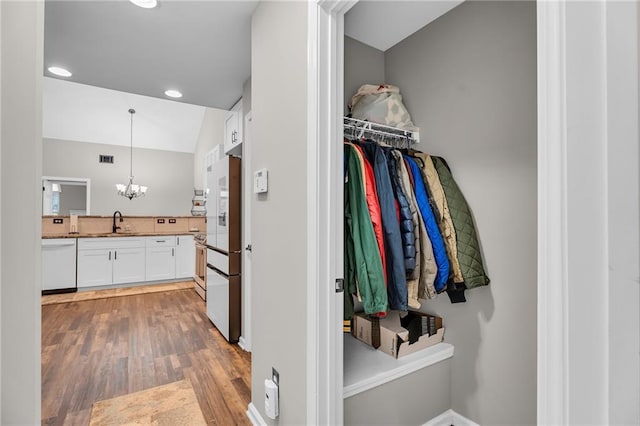 interior space with vanity, hardwood / wood-style floors, and an inviting chandelier