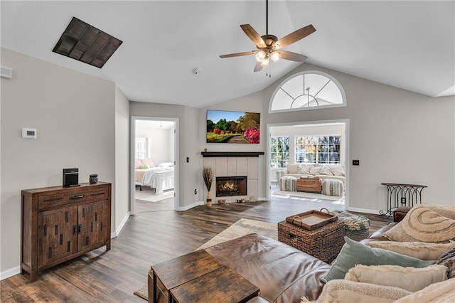 living room with a tiled fireplace, lofted ceiling, dark hardwood / wood-style floors, and ceiling fan