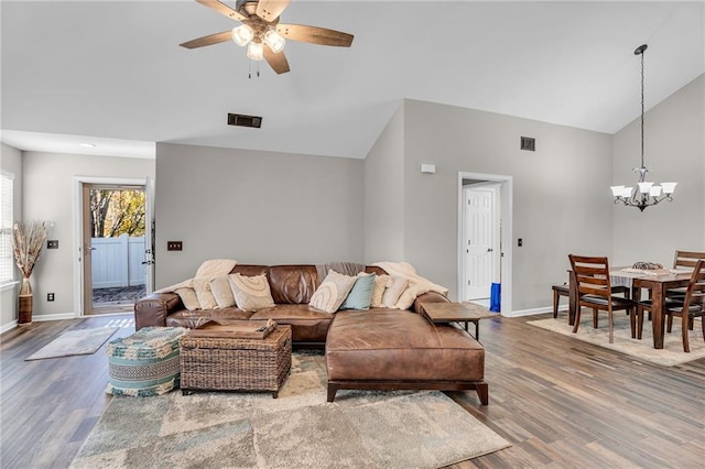 living room with high vaulted ceiling, wood-type flooring, and ceiling fan with notable chandelier