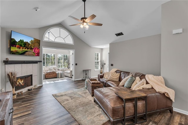 living room with a tile fireplace, high vaulted ceiling, dark hardwood / wood-style floors, and ceiling fan