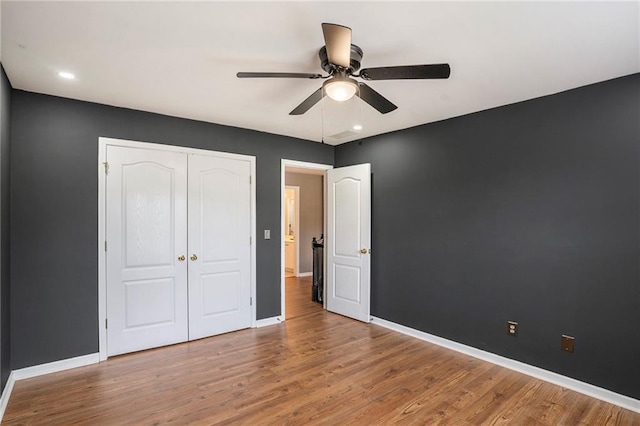 unfurnished bedroom with hardwood / wood-style floors, a closet, and ceiling fan