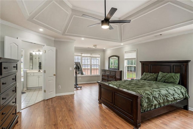 bedroom featuring ceiling fan, light hardwood / wood-style floors, ornamental molding, and ensuite bath