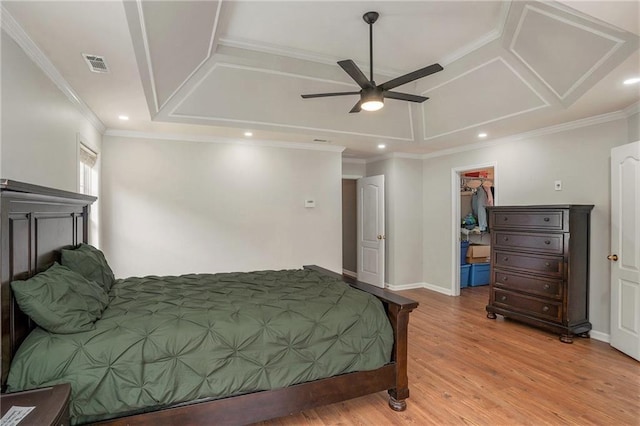 bedroom featuring ornamental molding, ceiling fan, a spacious closet, light hardwood / wood-style flooring, and a closet