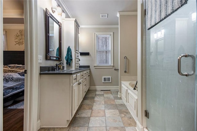 ensuite bathroom with a garden tub, crown molding, a stall shower, vanity, and baseboards