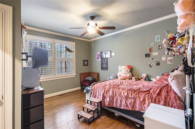 bedroom with a ceiling fan, baseboards, ornamental molding, and wood finished floors