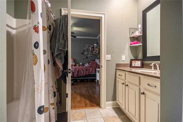 ensuite bathroom featuring connected bathroom, vanity, a shower with curtain, ornamental molding, and tile patterned floors