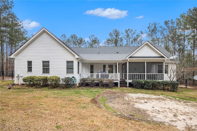 ranch-style house featuring a shingled roof, a front yard, and a sunroom