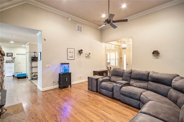 living room with visible vents, crown molding, light wood-style flooring, and baseboards