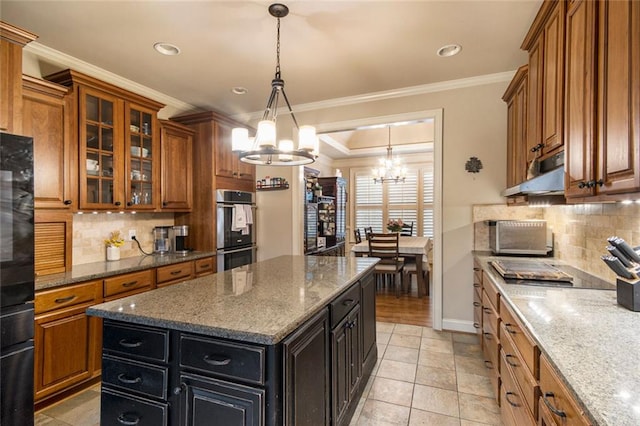 kitchen featuring brown cabinets, ornamental molding, double oven, dark cabinetry, and under cabinet range hood