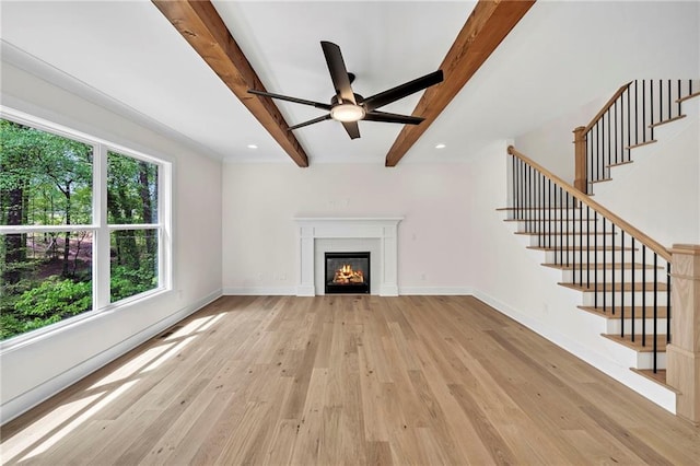 1664 Crestridge Dr SE, Marietta, GA 30067 - unfurnished living room featuring beam ceiling, stairs, light wood finished floors, a ceiling fan, and a glass covered fireplace