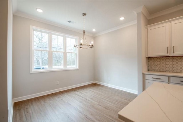 unfurnished dining area with crown molding, visible vents, baseboards, and light wood finished floors